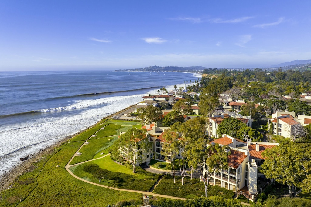 drone / aerial view featuring a water view and a view of the beach