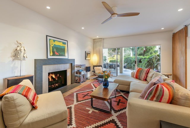 living room with a fireplace, wood-type flooring, and ceiling fan