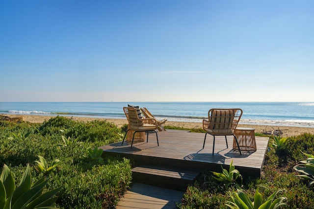 wooden terrace featuring a view of the beach and a water view