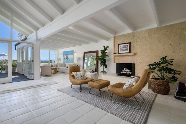 interior space featuring a tile fireplace, french doors, and beamed ceiling