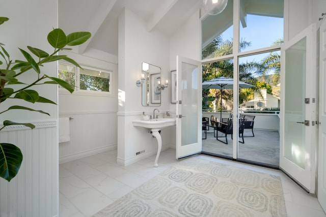 bathroom featuring high vaulted ceiling