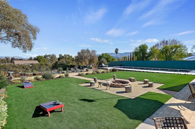 view of community with a yard and an outdoor fire pit