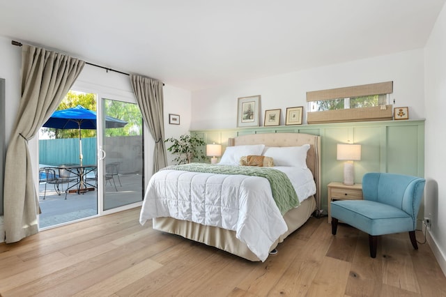 bedroom featuring access to exterior and light wood-type flooring