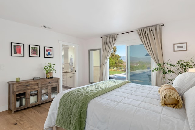 bedroom featuring access to exterior, hardwood / wood-style floors, and ensuite bathroom