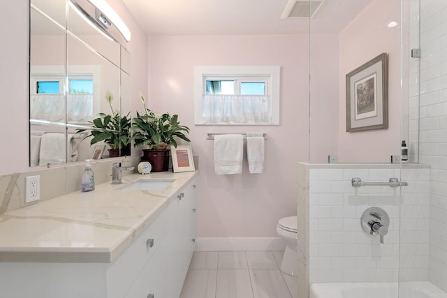 bathroom featuring tile patterned floors, vanity, toilet, and a shower