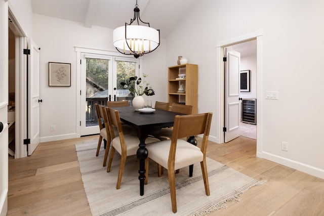 dining space featuring french doors, lofted ceiling with beams, a notable chandelier, light hardwood / wood-style floors, and beverage cooler