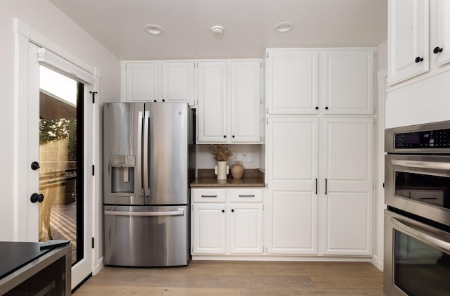 kitchen featuring light hardwood / wood-style flooring, white cabinets, and stainless steel appliances