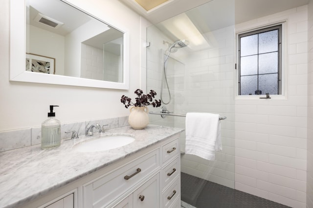 bathroom featuring vanity and tiled shower