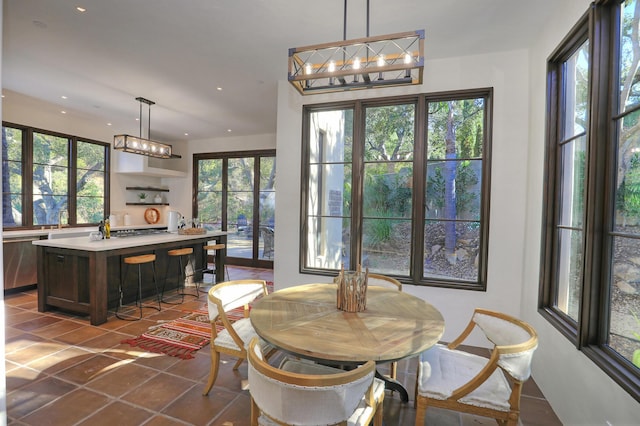 dining space with french doors, dark tile patterned floors, and sink