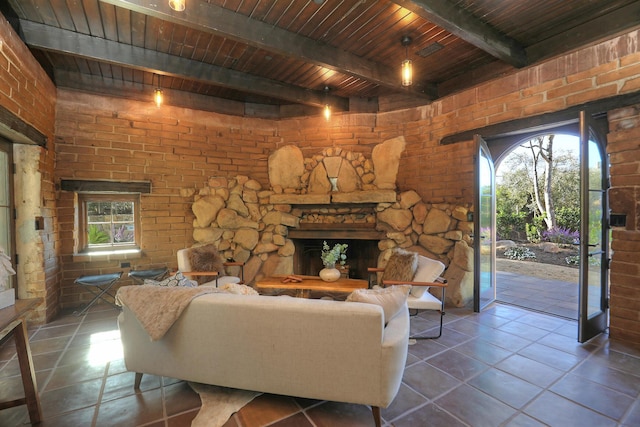 living room featuring dark tile patterned floors, a fireplace, beamed ceiling, and wood ceiling