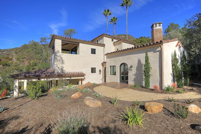 rear view of house featuring a mountain view and french doors