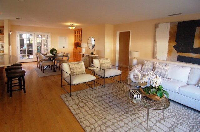 living room with french doors and light hardwood / wood-style flooring