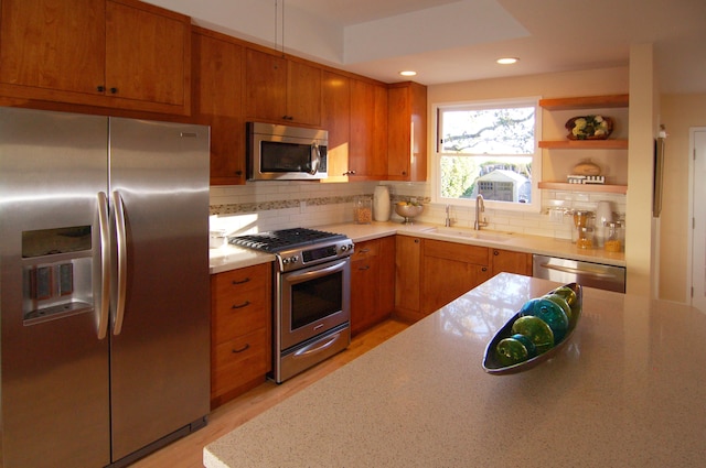 kitchen featuring light hardwood / wood-style floors, sink, stainless steel appliances, and tasteful backsplash