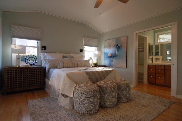 bedroom featuring hardwood / wood-style floors, ceiling fan, multiple windows, and vaulted ceiling