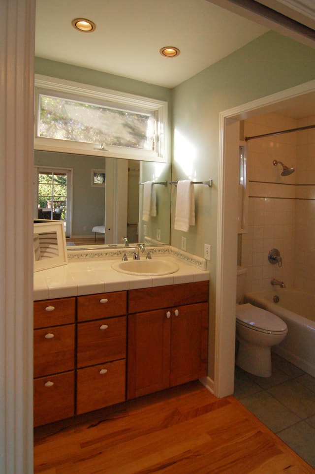 full bathroom featuring tile patterned floors, vanity, toilet, and tiled shower / bath