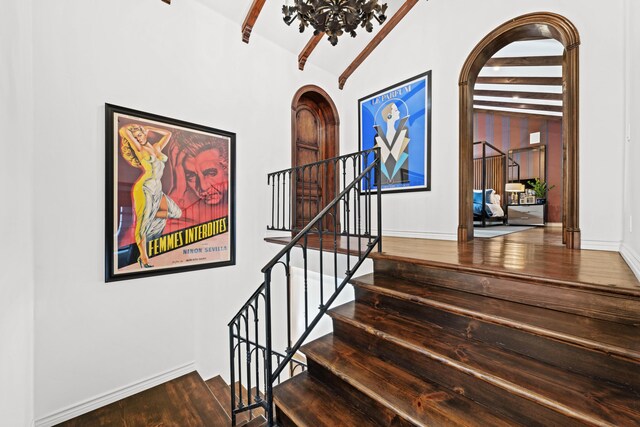 stairs with vaulted ceiling with beams and hardwood / wood-style floors