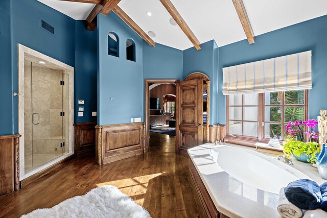 bathroom with hardwood / wood-style floors, lofted ceiling with beams, and separate shower and tub