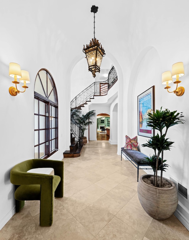 entryway with a high ceiling and an inviting chandelier