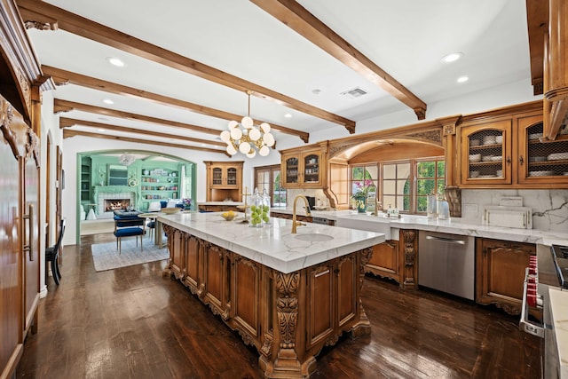 kitchen featuring tasteful backsplash, a kitchen island with sink, beam ceiling, dishwasher, and hanging light fixtures