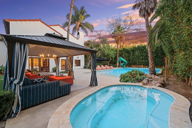 pool at dusk with a patio