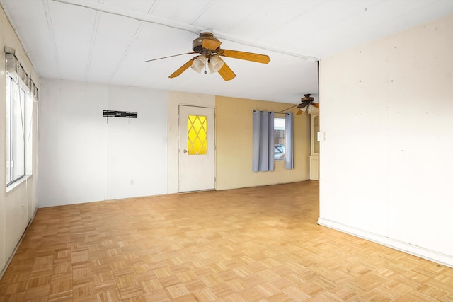 unfurnished room featuring light parquet floors, plenty of natural light, and ceiling fan