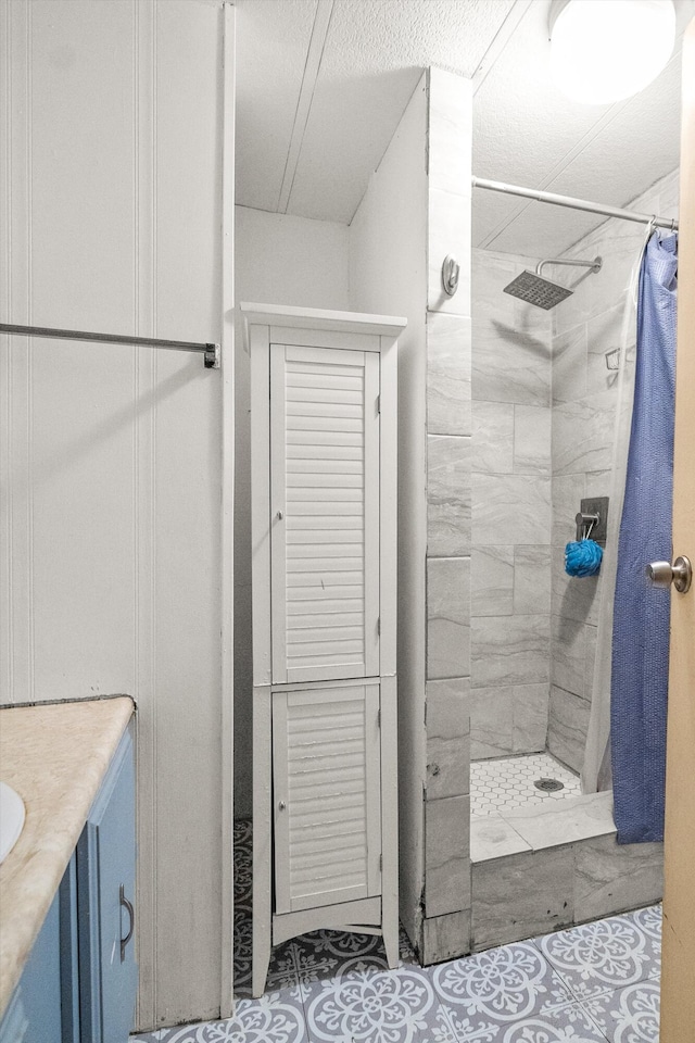 bathroom with a shower with shower curtain, vanity, and a textured ceiling