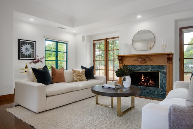 living room with plenty of natural light, wood-type flooring, and a premium fireplace