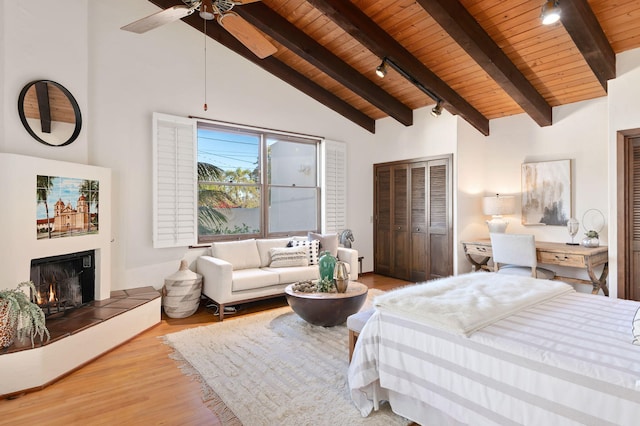 bedroom featuring ceiling fan, beamed ceiling, light wood-type flooring, high vaulted ceiling, and wooden ceiling