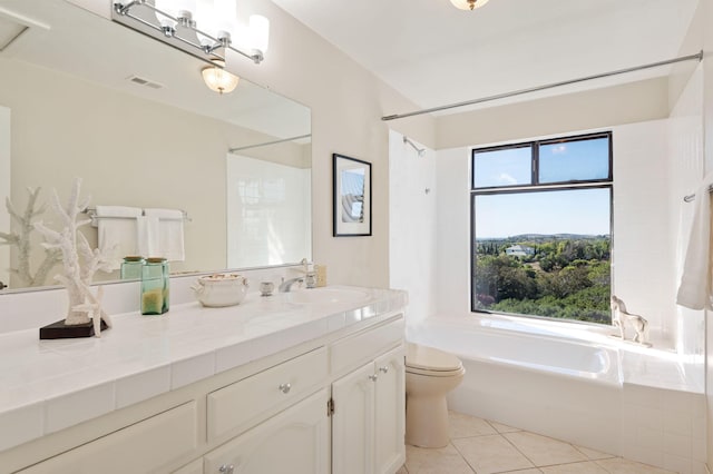 bathroom featuring a tub, toilet, vanity, and tile patterned flooring