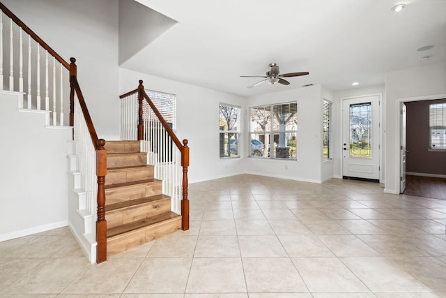 entrance foyer with stairs, plenty of natural light, light tile patterned flooring, and baseboards