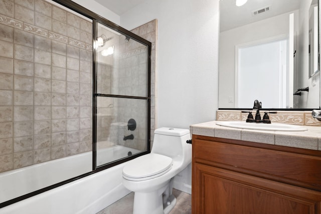 bathroom with toilet, visible vents, combined bath / shower with glass door, and vanity