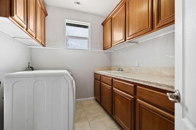 laundry room with light tile patterned flooring, a sink, visible vents, cabinet space, and washer / dryer