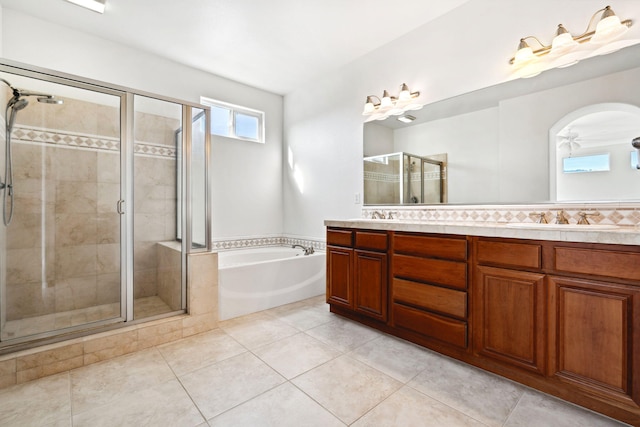 bathroom featuring a garden tub, a sink, a shower stall, tile patterned floors, and double vanity