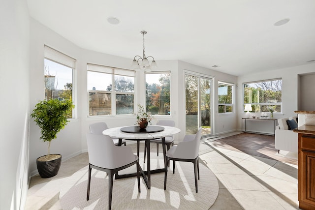 sunroom / solarium featuring an inviting chandelier