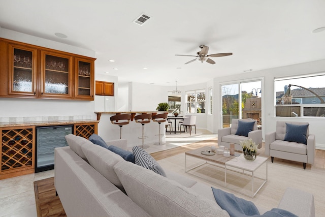 living area with ceiling fan, recessed lighting, beverage cooler, visible vents, and a bar