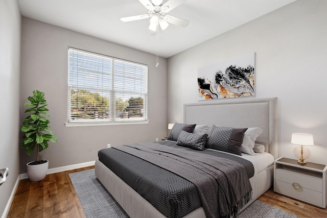 bedroom featuring a ceiling fan, baseboards, and wood finished floors