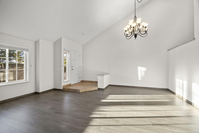 interior space featuring dark wood-type flooring, high vaulted ceiling, and a chandelier