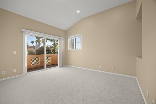 carpeted spare room featuring vaulted ceiling