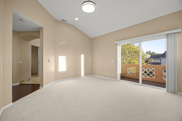 carpeted spare room featuring lofted ceiling