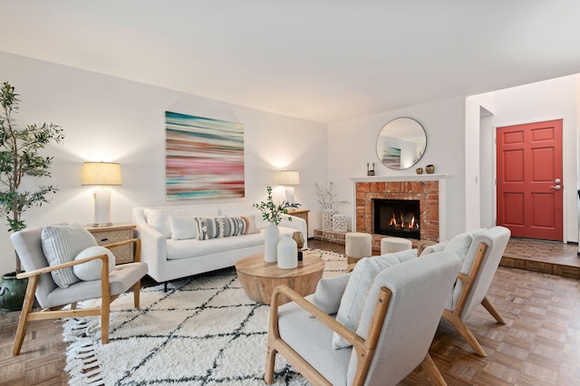 living room with a brick fireplace and light parquet floors