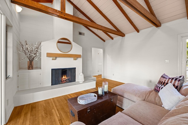 living room with beamed ceiling, wood-type flooring, and high vaulted ceiling