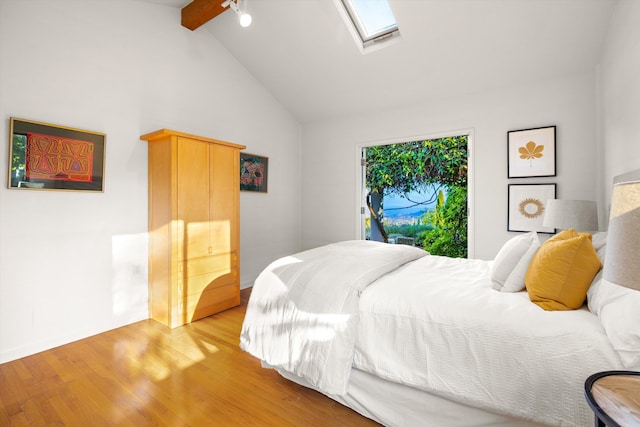 bedroom with light hardwood / wood-style floors, lofted ceiling with skylight, and ceiling fan