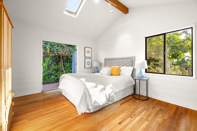 bedroom with light hardwood / wood-style flooring and lofted ceiling with skylight