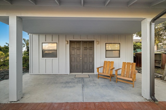 view of exterior entry with a patio area