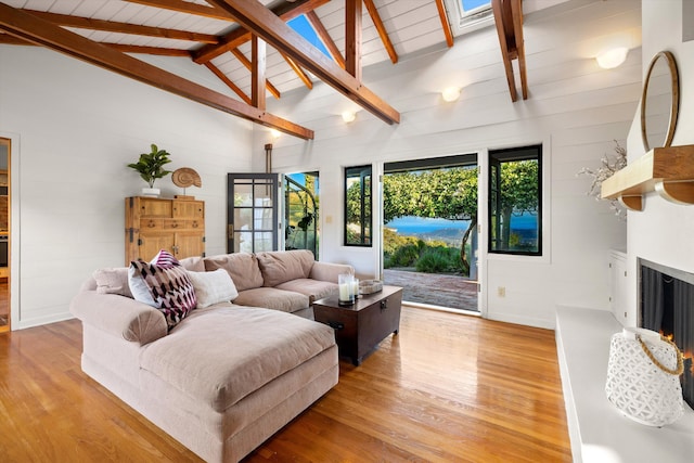 living room with beamed ceiling, light hardwood / wood-style floors, high vaulted ceiling, and wood ceiling