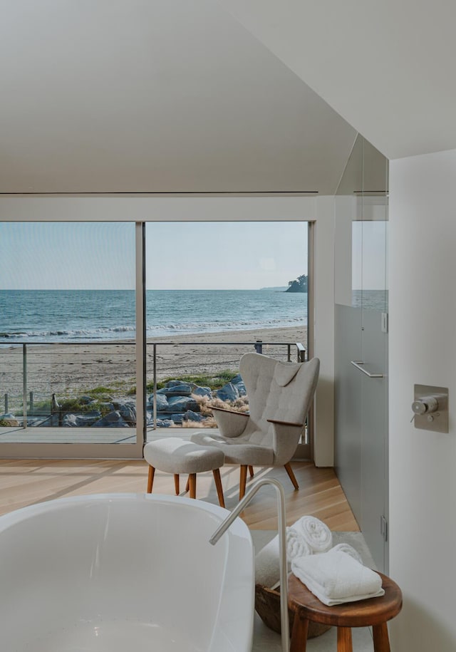 balcony with a water view and a view of the beach