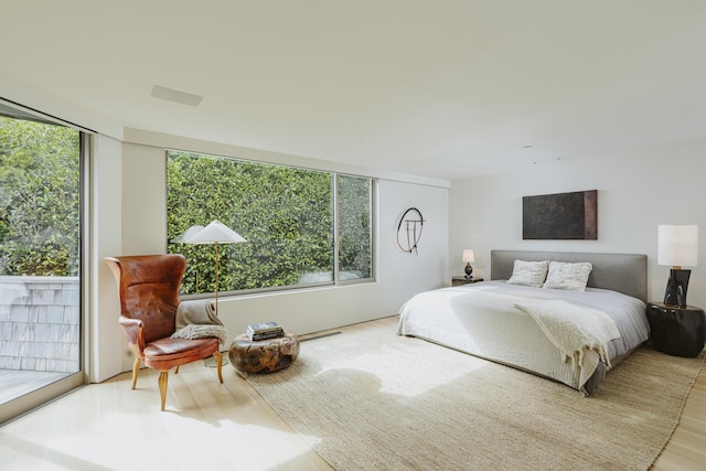 bedroom featuring access to exterior and light hardwood / wood-style flooring