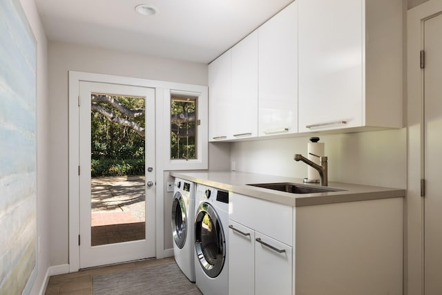 washroom with hardwood / wood-style floors, washer and dryer, cabinets, and sink