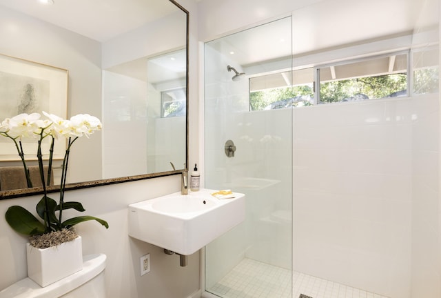 bathroom featuring toilet and a shower with door