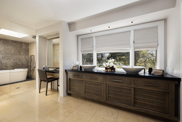 kitchen featuring dark brown cabinetry, sink, light tile patterned floors, and tile walls